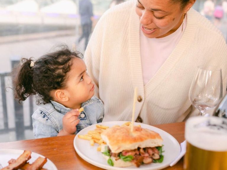 Image of a young girl and her mother enjoying a sandwich at The General Assembly, a popular family-friendly restaurant in South Wharf, Victoria.