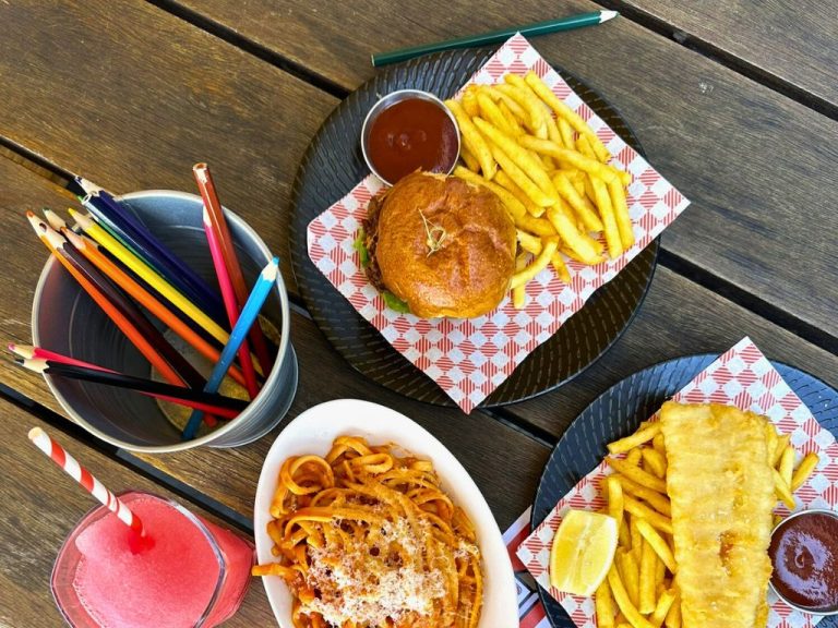 Image of delightful kids' meals featuring spaghetti, a burger with chips, and fish with chips, accompanied by drawing pencils, available at The General Assembly. Located in South Wharf, Victoria, this beloved family-friendly restaurant is renowned for its welcoming atmosphere and delicious menu, making it a perfect choice for families.